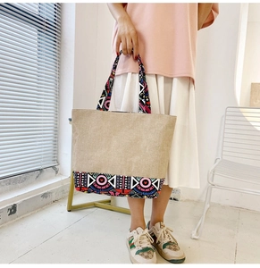 Detail of colorful geometric patterns on ethnic canvas tote bag with beige fabric