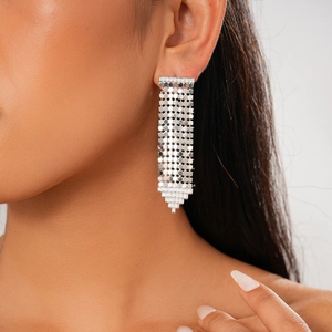 Gros plan de boucles d'oreilles pompons plaquées or 18K avec zircons sur un mannequin
