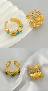 Detail of gold stainless steel rings featuring malachite inlay and hollow flower patterns