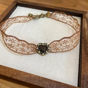 Vintage brown lace choker with a resin heart pendant and bronze metallic clasp detail