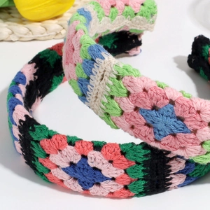 Close-up of handmade crochet headbands with colorful granny square floral patterns