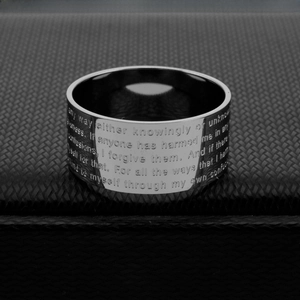 Polished silver titanium steel ring with engraved biblical text on black textured surface
