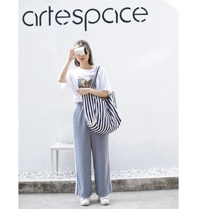 Blue and white striped canvas tote bag styled with a casual street outfit in a bright setting