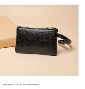 Detail of black pebbled leather mini purse with gold zippers and detachable wrist strap