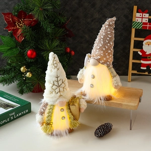 Set of two glowing Christmas gnomes with warm LED lights in cream and camel fabric
