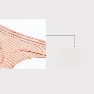 Detail view of pink ribbed cotton thong showing low-rise waist and elastic hollow decoration