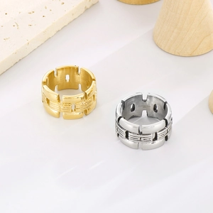 Makro-Detail breiter hohler geometrischer Ringe in gebürstetem Gold und poliertem Silber