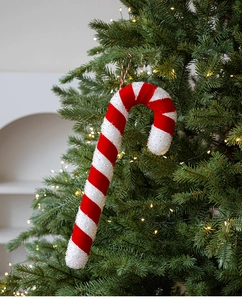 Detail of red and white striped candy cane ornament with glitter texture on Christmas tree
