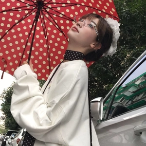 Écharpe à pois noirs et blancs de style français portée avec un haut blanc à manches