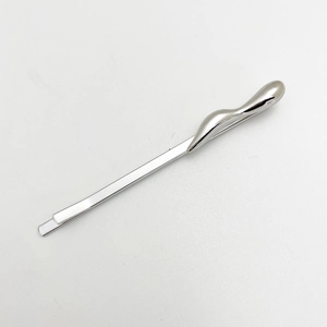 Close-up of a silver wavy metal hair clip with a sleek polished finish on white background