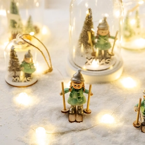 Boule de neige Noël avec fille skieuse et lumières LED sur socle enneigé blanc