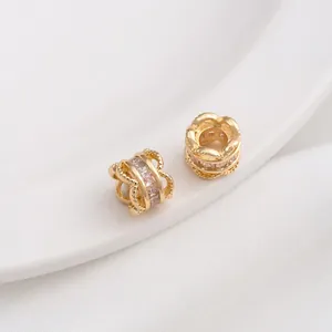 Macro shot of 14K gold-filled spacer beads with cubic zirconia and hollow lace design