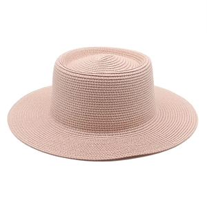 Detailed close-up of woven straw texture and concentric pattern on pink sun hat