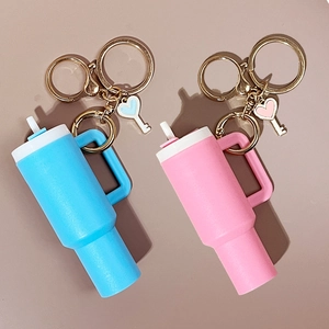 Detail of pink and blue mini tumbler keychains with heart charms and gold metal hooks