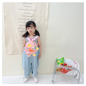 Toddler backpack detail featuring pink fabric with colorful cartoon dinosaurs and palm trees