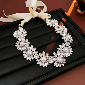 Detailed macro view of crystal flower necklace with pearl centers and beige silk ribbon tie