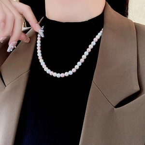 Close-up of multicolor pearl necklace with white pink and orange pearls on a model