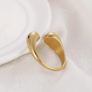 Detailed view of an adjustable gold-plated stainless steel ring on white textured fabric