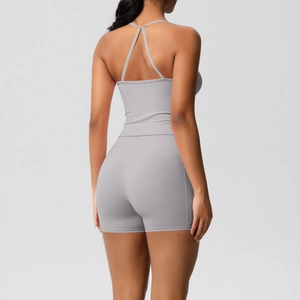 Detail of grey open back yoga top and high waist sports shorts on a female model