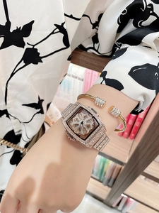 Close-up of rose gold tonneau watch and bracelet set with rotating floral dial and crystals