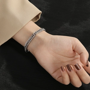 Close-up of men's titanium steel cuban link bracelet worn on wrist with sleek metallic shine