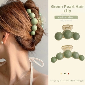 Close-up of green pearl-style hair claw clip made of smooth acrylic beads for women