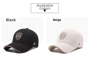 Detail view of beige and black baseball caps with classic shield embroidery on front