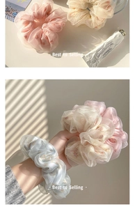 Detailed view of sheer floral scrunchies in soft pastel pink, beige and light blue tones