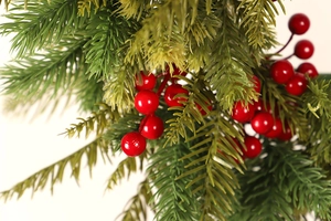 Detailed close-up of realistic red berries and green pine needles on Christmas wreath