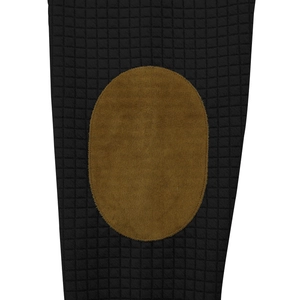 Detail of checkered quilted fabric with brown oval suede elbow patch and fine stitching