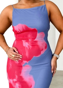 Détail des fines bretelles et de l'imprimé floral rouge sur la robe bleue moulante
