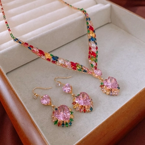 Macro view of pink heart pendant with rainbow zircon inlay in a luxury jewelry box