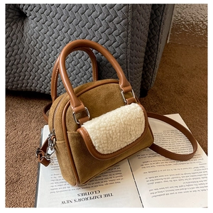 Close-up of brown faux suede and white plush faux fur handbag on a vintage book