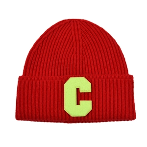 Detail of red ribbed knit beanie featuring a bright yellow letter C patch for winter