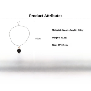Detail view of acrylic Saturn pendant on a long black cord necklace with wood material