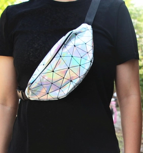 Holographic geometric patchwork waist bag worn as a crossbody bag with adjustable strap