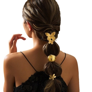 Elegant gold butterfly and floral metal hair ties set shown on a bubble braid hairstyle