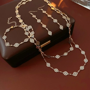 Golden cutout diamond cloud jewelry set with necklace bracelet and earrings on leather case