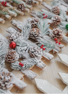 Detail of wooden Christmas fence with natural pine cones, red berries and snow effect