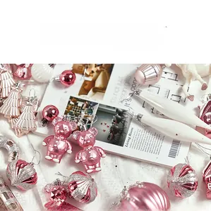 Detailed view of pink and white Christmas ornaments including bear and tree shaped pendants