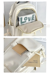 Detail view of large capacity white backpack showing interior storage and zipper texture