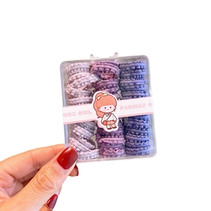 Purple gradient wave hair ties for kids in a gift box held by a female hand