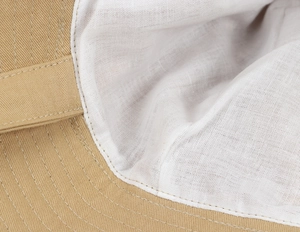 Detail of khaki cotton fabric and breathable white lining with neat stitching on sun hat