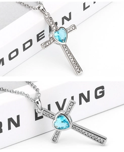 Detail of cross heart pendant with light blue crystal and white cubic zirconia accents