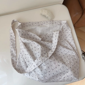 Vue détaillée du sac cabas en coton gris clair avec motif floral et large bandoulière