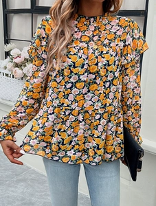 Detail of floral print blouse showing ruffled cuffs and lightweight fabric texture