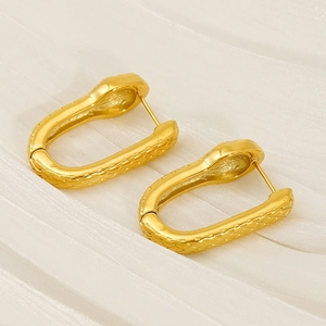 Golden U-shaped titanium steel earrings with snake skin pattern on white fabric