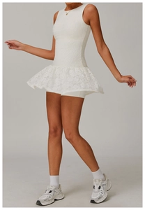 Close-up of white lace sleeveless sports dress with tiered ruffled hem and breathable mesh