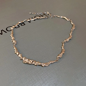 Dettaglio della catena d'argento con maglie irregolari e finitura metallica lucida