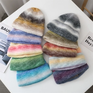 Macro shot of colorful tie-dye gradient knit beanies neatly stacked on a clean surface